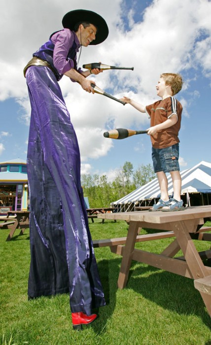 Nikolai teaches six-year-old Damian Volaine to juggle on the midway at Fort Edmonton Park. 2007.